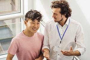 Two young men having a discussion while walking up stairs.